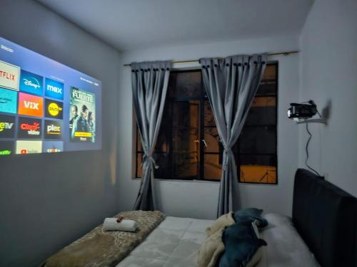 1 dormitorio con 1 cama y una ventana con cortinas en Casa Samor La Candelaria, en Bogotá