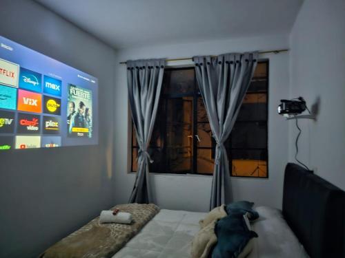 een slaapkamer met een bed en een raam met gordijnen bij Casa Samor La Candelaria in Bogota