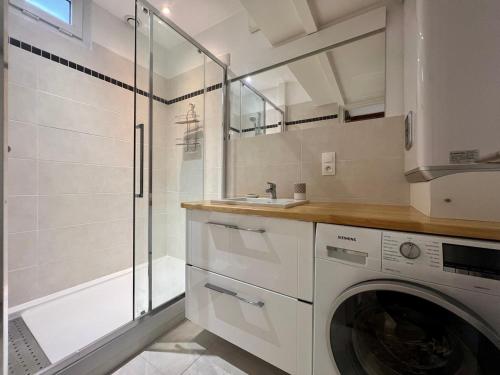 La salle de bains est pourvue d'un lave-linge et d'une douche. dans l'établissement Le 46 Magenta - Grand Duplex en hypercentre, à Poitiers