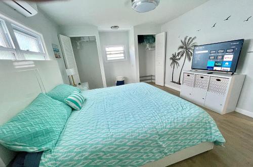 a bedroom with a large bed and a flat screen tv at Tropical Oasis near beach in Naples