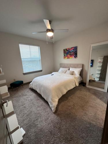 a bedroom with a large bed and a ceiling fan at Stylish-homes in Fort Worth
