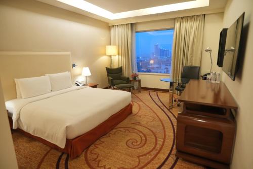 a hotel room with a bed and a desk and a window at DoubleTree by Hilton Gurgaon New Delhi NCR in Gurgaon