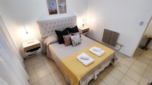 um quarto com uma cama grande com duas almofadas em Ainhoa Beach MDP - A Pasos del Mar em Mar del Plata