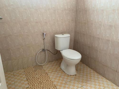 a bathroom with a white toilet in a room at Mandi Angin "Syariah" Homestay in Bukittinggi