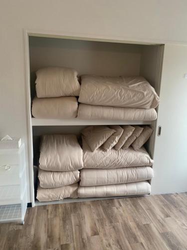 a closet filled with lots of pillows at オーシャンビューFORTUNA YAKA Ace 12名対応 海まで徒歩 シャワールーム 2 BBQ OK in Kin
