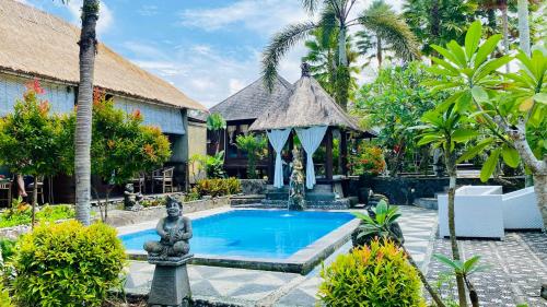 a resort pool with a statue and a gazebo at Dong Loka Guesthouse Bali in Payangan