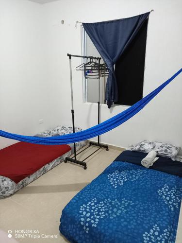 a room with two beds and a hammock at The Backpacker Nomad Green Apartment in Cancún