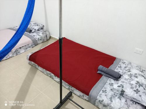 a bed in a room with a red blanket at The Backpacker Nomad Green Apartment in Cancún