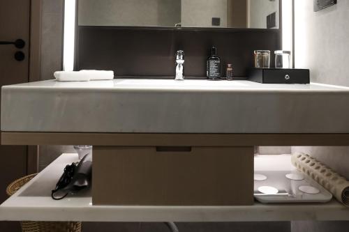 a bathroom with a white sink and a mirror at Somerset Chayuan Chongqing in Chongqing
