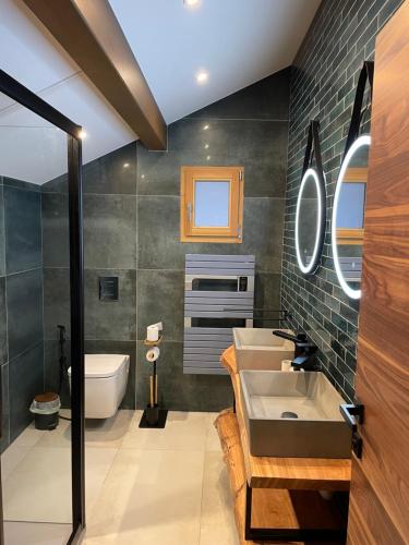 a bathroom with two sinks and a tub and a toilet at Chalet Cristal II in Les Contamines-Montjoie