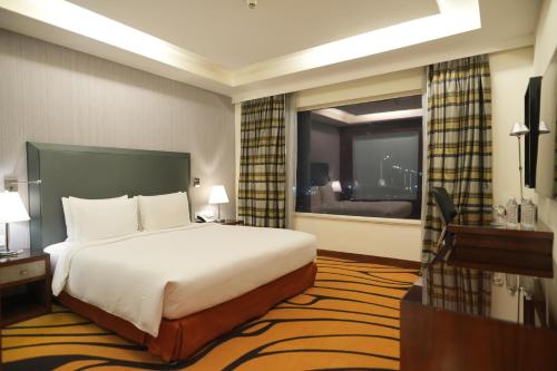 a hotel room with a bed and a large window at DoubleTree by Hilton Gurgaon New Delhi NCR in Gurgaon
