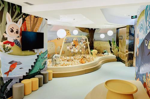 Sheraton Zhanjiang Hotel في زانجيانغ: غرفة للأطفال مع تلفزيون ومنطقة لعب