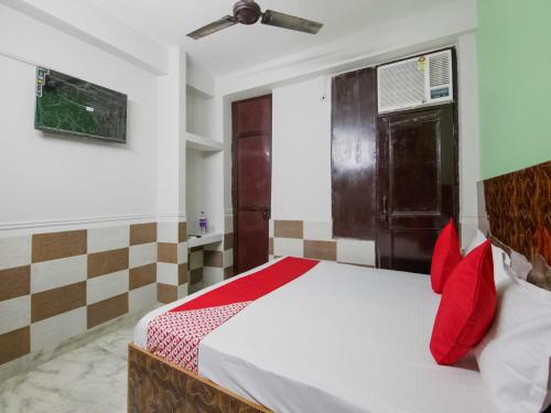 a bedroom with a bed with red pillows at OYO Flagship Hotel Green Light in New Delhi