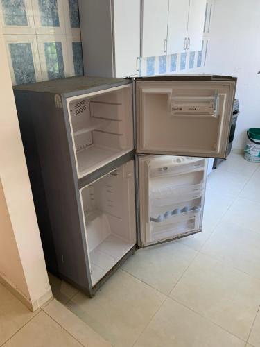 an empty refrigerator with its door open in a kitchen at Cabaña Roman in Cartagena de Indias