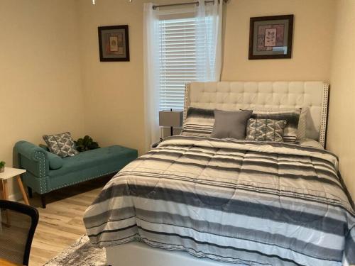 ein Schlafzimmer mit einem Bett und einer grünen Couch in der Unterkunft Stylishly designed basement. in Lawrenceville