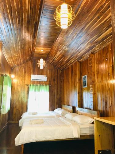 a bedroom with a large bed in a wooden wall at Baan Sangchan in Ko Kood