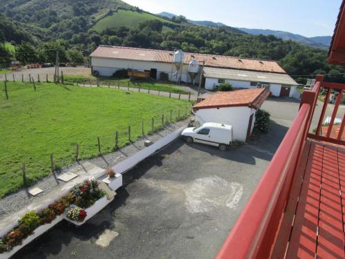 a white truck parked in a parking lot next to a building at Etxexuriko Borda in Aïnhoa