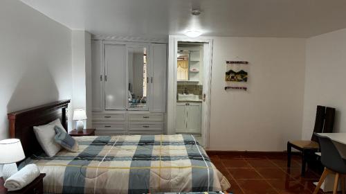 1 dormitorio con 1 cama y lavamanos. en Kimsa Wasi I, en Otavalo