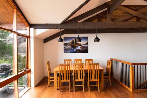 a dining room with a wooden table and chairs at Heidelburg 3 of 6 Banjo Patterson Crescent in Jindabyne