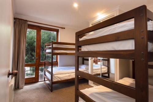 a room with three bunk beds and a window at Heidelburg 3 of 6 Banjo Patterson Crescent in Jindabyne