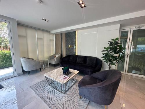 a living room with a couch and a table at AVALYN Room Plus II - East Ville in Ban Hua Khao Sammuk