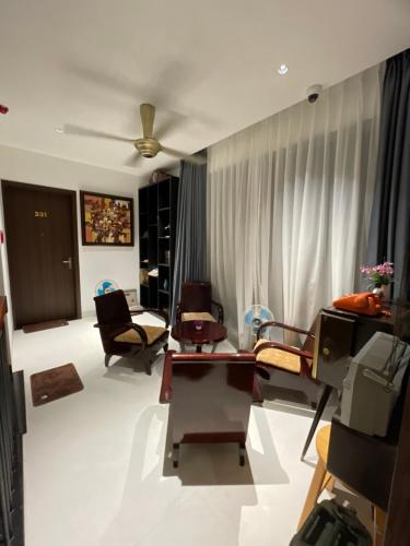 a living room with chairs and a ceiling fan at The Dragon Villa Hoi An in Hoi An