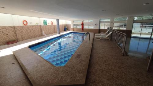 a large swimming pool in a large building at Hotel Fundacooedumag Rodadero in Santa Marta