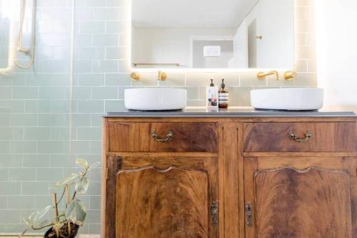 a bathroom with two sinks on a wooden cabinet at NEW! Funky 2BR Chermside Escape in Brisbane