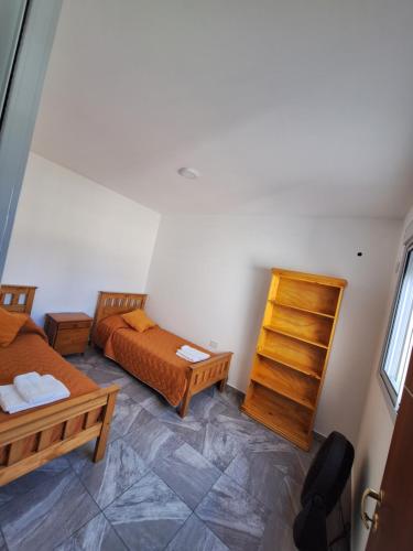 een kleine kamer met 2 bedden en een stoel bij Alem in Villa María