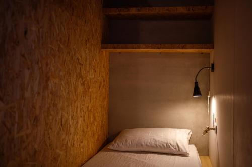 a bed in a small room with aermottermottermottermott at Slow Island Hostel in Green Island