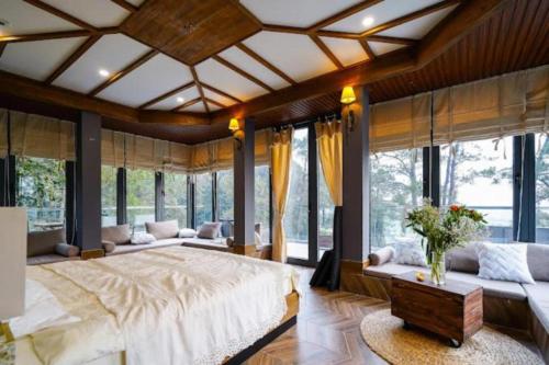 ein großes Schlafzimmer mit einem großen Bett und großen Fenstern in der Unterkunft Cao Vintage Villa - Venuestay in Tam Ðảo