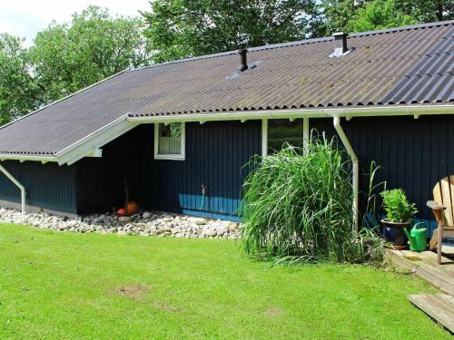 a blue house with a yard in front of it at 8 person holiday home in Juelsminde in Sønderby