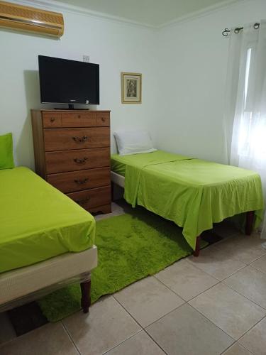 1 dormitorio con 2 camas y un tocador con TV en Encharted at Winchester 2Bedrooms en Kingston