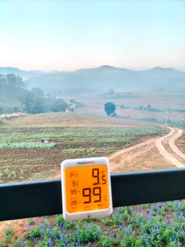 a thermometer on a fence looking at a road at สวนไร่รุ่งอรุณ Suan Rai Rungarun in Ban Na Pa Paek