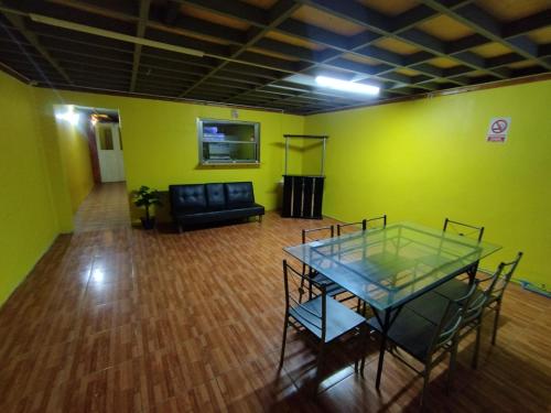 uma sala de estar com uma mesa de vidro e um sofá em CASA EN LOS VERDES em Iquique