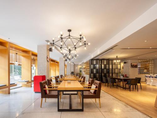 a dining room with tables and chairs and a chandelier at Waito Hotel Yuexiu Park Guangzhou in Guangzhou
