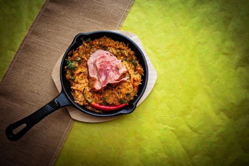 a pan of food with meat and rice on a table at Hotel Riviera in Sinaia