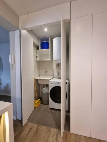a kitchen with a washing machine and a sink at DEPARTAMENTO KILLA HUATANA in Cusco