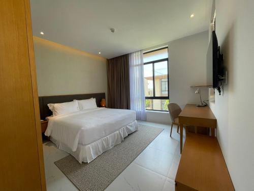 um quarto com uma cama, uma secretária e uma televisão em Big Star Villas - Wyndham Garden em Cam Ranh