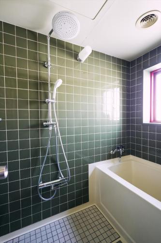 a green tiled bathroom with a tub and a shower at 「まちの隠れ家ペントハウス」ロフトベッド付き！｜ STAY UWU 003 Penthouse in Kochi