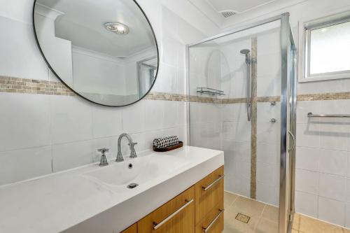 a white bathroom with a sink and a mirror at Avalon 2 in Nambucca Heads
