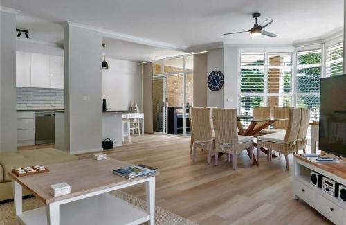 a living room with a table and a dining room at Ocean Spray Sawtell in Sawtell