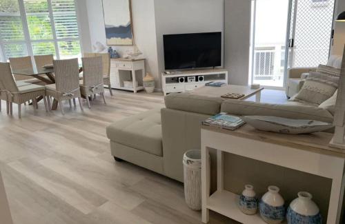 a living room with a couch and a table at Ocean Spray Sawtell in Sawtell