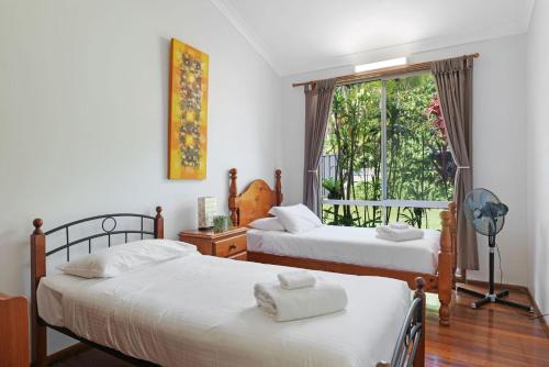1 dormitorio con 2 camas y ventana en Siesta by the Sea, en Coffs Harbour