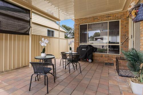 a patio with two tables and chairs on it at Serenity in Sunny Sawtell in Sawtell