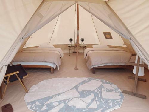 BhurkīāにあるBurhan Wilderness Campsのテント内のベッド2台が備わる部屋