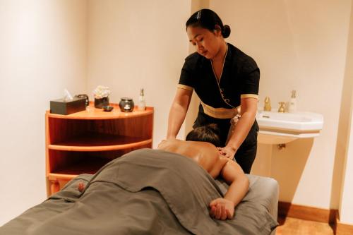 a woman is giving a man a massage at The Bellwood Manor in Nuwara Eliya