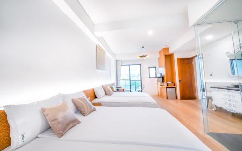 una habitación con tres camas blancas. en Penghu I Stay I, en Magong
