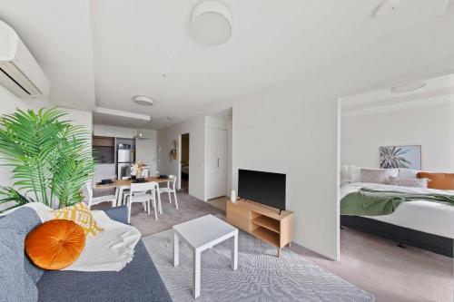 1 dormitorio y sala de estar con 1 cama y 1 sofá en A Cozy & Plush 2BR Apt Next to The Yarra River, en Melbourne