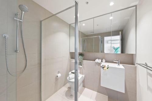 y baño con ducha y aseo. en A Cozy & Plush 2BR Apt Next to The Yarra River, en Melbourne